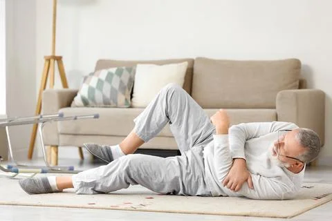 Senior man with walker lying on floor after fall at home Stock Photos