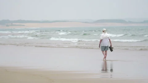 Senior man walking on the beach in 4k Stock Footage 152685688