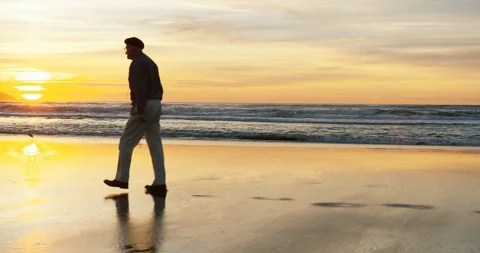 Senior man walking on the beach at sunset. Stock Footage 88374066