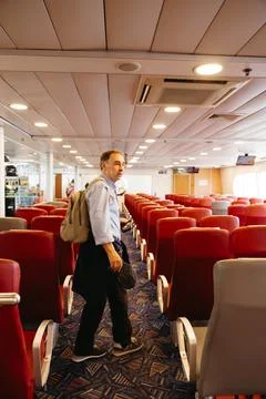 Senior man walking inside ferry passenger cabin Stock Photos