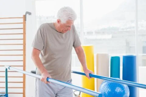 Senior man walking with parallel bars Stock Photos