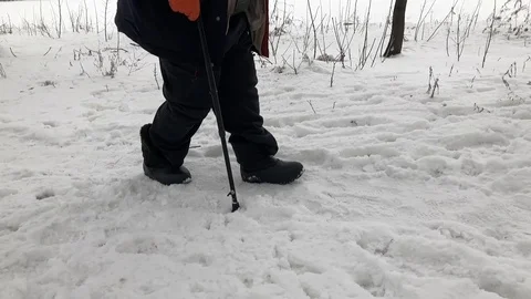 Senior man with walking stick walking hard on a snow covered path Stock Footage 123518405