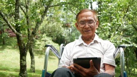 Senior man in wheelchair using digital tablet in the park. Stock Footage 155827727