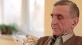 Senior man with white smartphone sits on the couch and listens to music HD Footage
