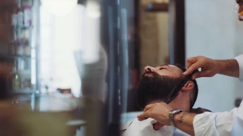 Senior man at work as barber cutting customer’s hair with pair of scissors  Stock Footage 71825389
