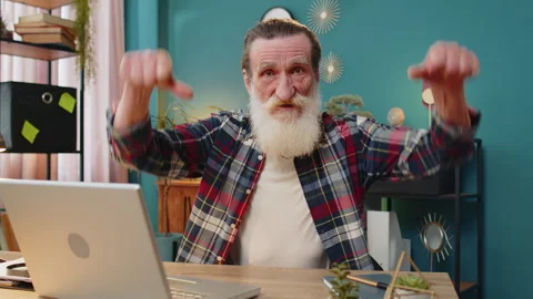 Senior man working on laptop computer at home office showing thumbs down sign Stock Footage 267627920