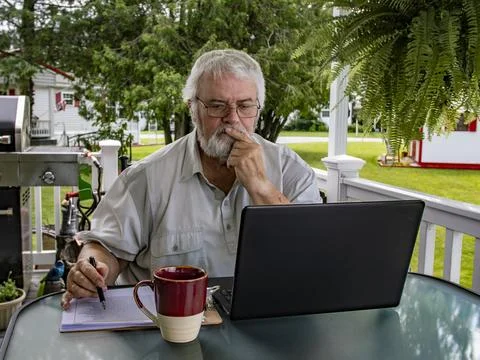 Senior Man Working on Laptop While Sitting at Table Outside During Daytime Stock Photos