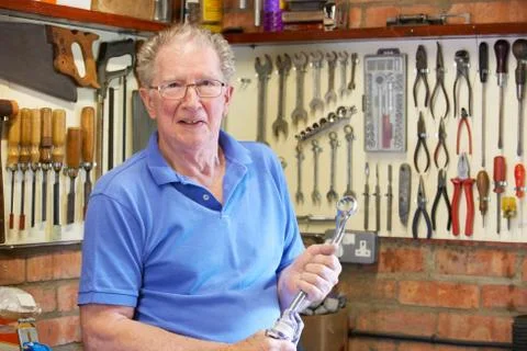 Senior Man in Workshop Standing With Tools Foto stock
