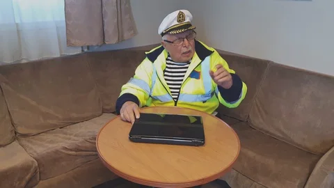 Senior man in yellow protective jacket sits on sofa at table Stock Footage 127685008