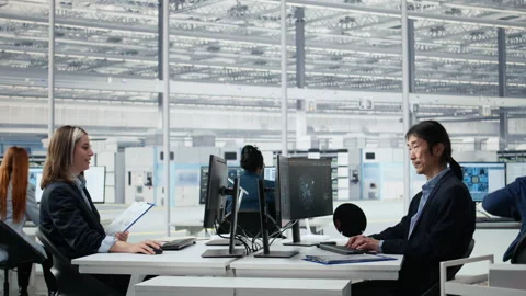 Senior manager analyzing chip architecture with AI model in microchip factory Stock Footage 335880043