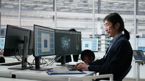 Senior manager analyzing chip architecture with AI model in microchip factory Stock Footage 335881537