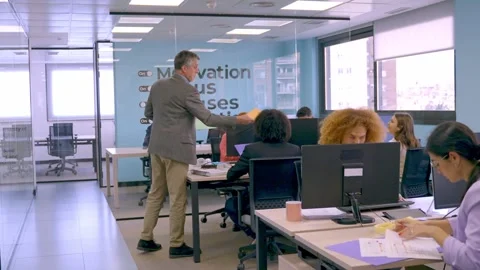 Senior manager distributing tasks in a bright office environment. Vídeo Stock 270765817