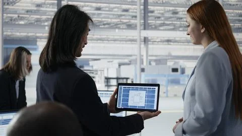 Senior manager doing microchips yield enhancement with worker using tablet 写真素材