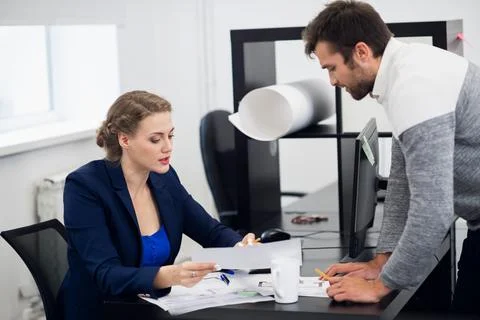 A senior manager explaining something to her team member, while Stock Photos