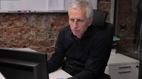 Senior manager works at computer sitting at workplace in large company. Stock Footage 83229095