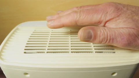 A senior man’s hand pressing to start an appliance then testing the air flow. Stock Footage 296099702