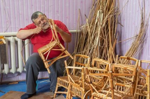 Senior master of wicker-work making kids chair Stock Photos