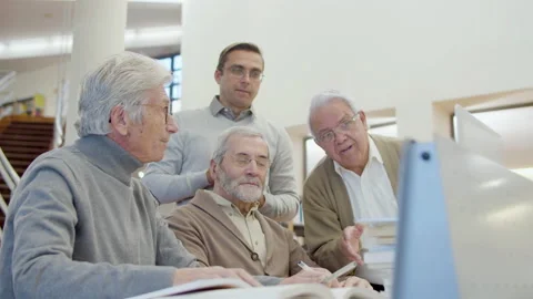 Senior men and teacher looking laptop screen in library Stock-Footage 232623385