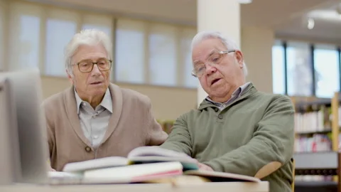 Senior men in eyeglasses talking while having lesson in library Stock-Footage 232622139