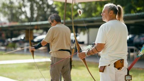 Senior men practicing archery, aiming for goals Stock Photos