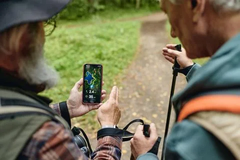 Senior Men Using Navigation Map App on Smartphone While Hiking Stock Photos