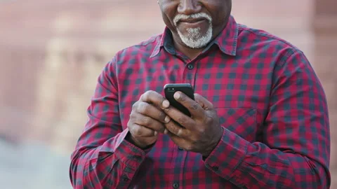 Senior middle aged black man holding modern device smart phone using mobile app Stock Footage 162698663