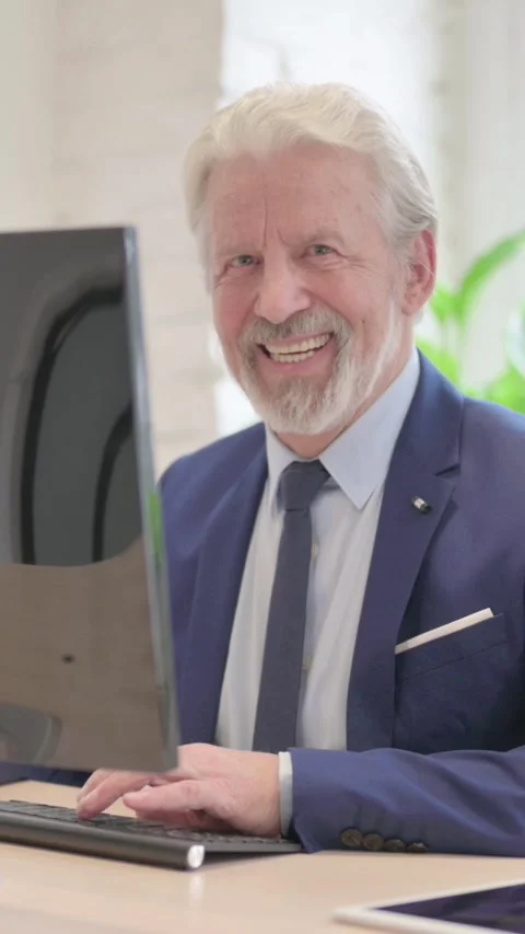 Senior Old Businessman Smiling at Camera while Using Desktop Computer, vertical Video stock 328974376