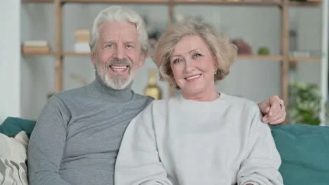 Senior Old Couple Sitting on Sofa and Smiling at Camera Vidéo 148201836