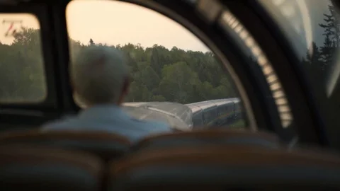 A senior / old man sitting in front of a window of a sightseeing train - Stock Footage 108174948
