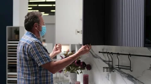 Senior opens the cupboards in the kitchen unit. Shopping precautions Stock Footage 160311325