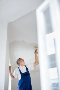 Senior painter man at work with a paint bucket, wall painting concept 스톡 사진