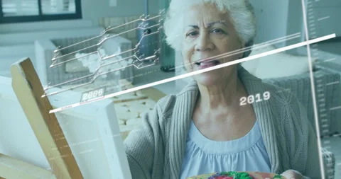 Senior painter mixing colors and painting canvas as technology timeline tracking Stock Footage 315560331