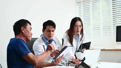 Senior patient meets with doctors using tablet and laptop in modern clinic... Stock-Footage 312665916