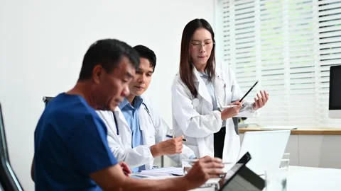 Senior patient meets with doctors using tablet and laptop in modern clinic... Stock-Footage 312665918