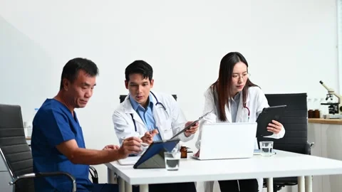 Senior patient meets with doctors using tablet and laptop in modern clinic... Stock-Footage 312665919