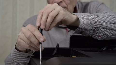 Senior pensioner fixes black outdated television back cover 库存影片 127152401