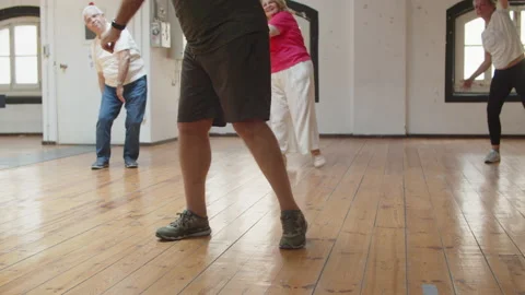 Senior people having dance class with teacher in ballroom Stock Footage