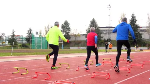 Senior people preparing training elements in a running track Stock Footage 258328627