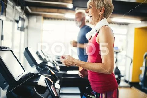 Senior people running in machine treadmill at fitness gym club Stock Photos