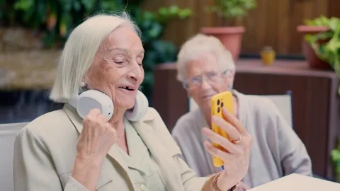 Senior people using phone and smiling in a nursing home Stock Footage 260847784