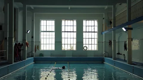 Senior People Watching Elderly Man Swimming Inside Classic Indoor Pool - 4K Stock Footage 345679665