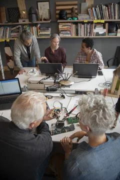 Senior people working in electronics workshop using soldering equipment Stock Photos