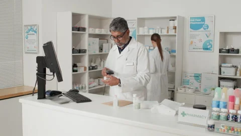 Senior Pharmacist Preparing Orders Scanning Medications in Pharmacy Stock Footage 334865209