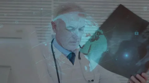 Senior physician lifting X-ray and diagnosing, blue globe overlay rotating and Stock Footage 329785092
