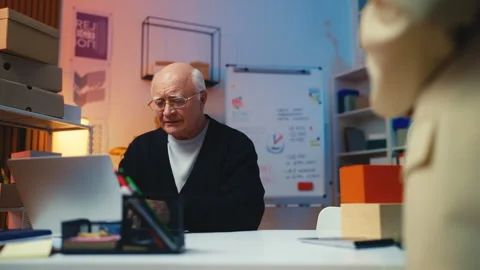 Senior post office worker handing a parcel to a customer while working on laptop Stock Footage 289393702