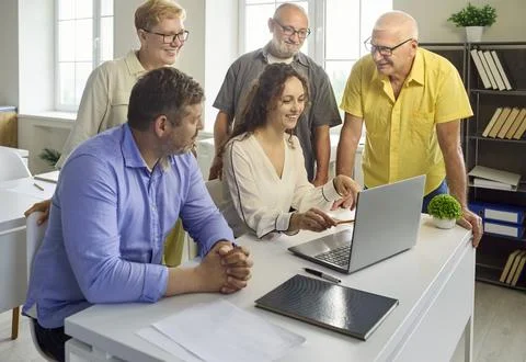 Senior professionals learning computer skills with instructor in office Stock Photos