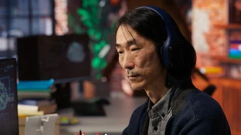 Senior programmer in AI startup office putting on headphones, close up Stock Photos