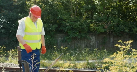 The senior railroader checks rails with repair mechanism of railway 動画素材 135572853
