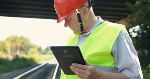 The senior railroader in uniform using tablet when checking a railway Stock Footage 135568902