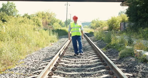 Senior railroader in uniform walking with tablet at the railway Stock Footage 135569147
